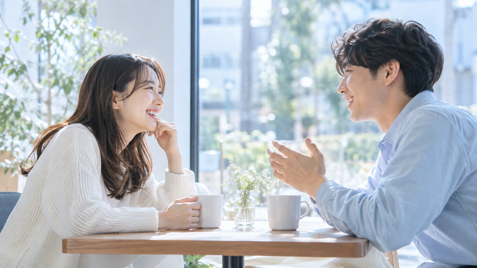 カフェのテーブルで向かい合って笑顔で話す男女