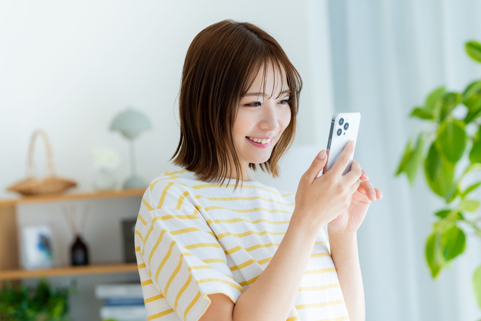 スマホを手に笑顔を見せる女性